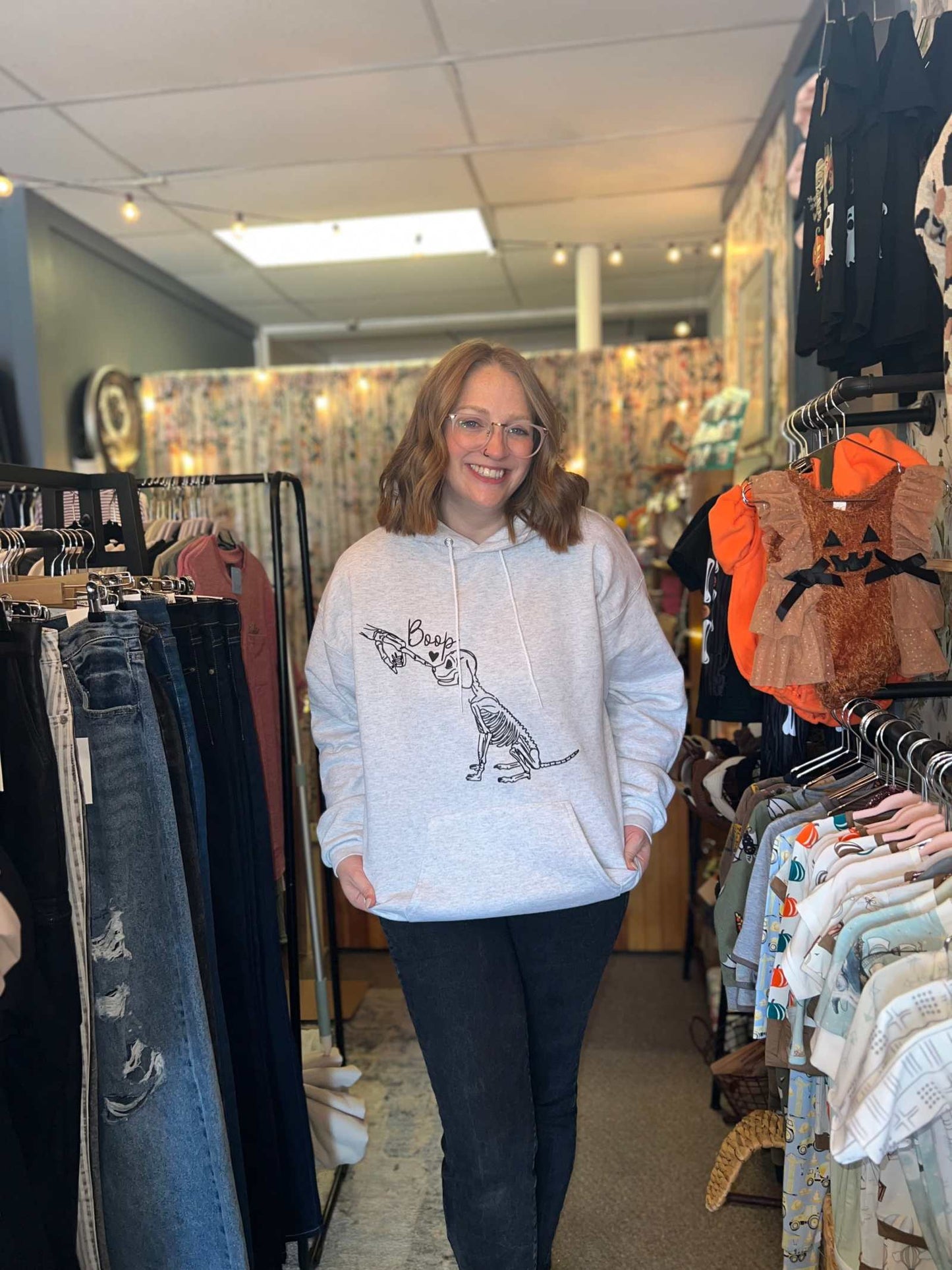 Halloween Graphic Skeleton Dog Custom Sweatshirt worn by a person in a clothing store.