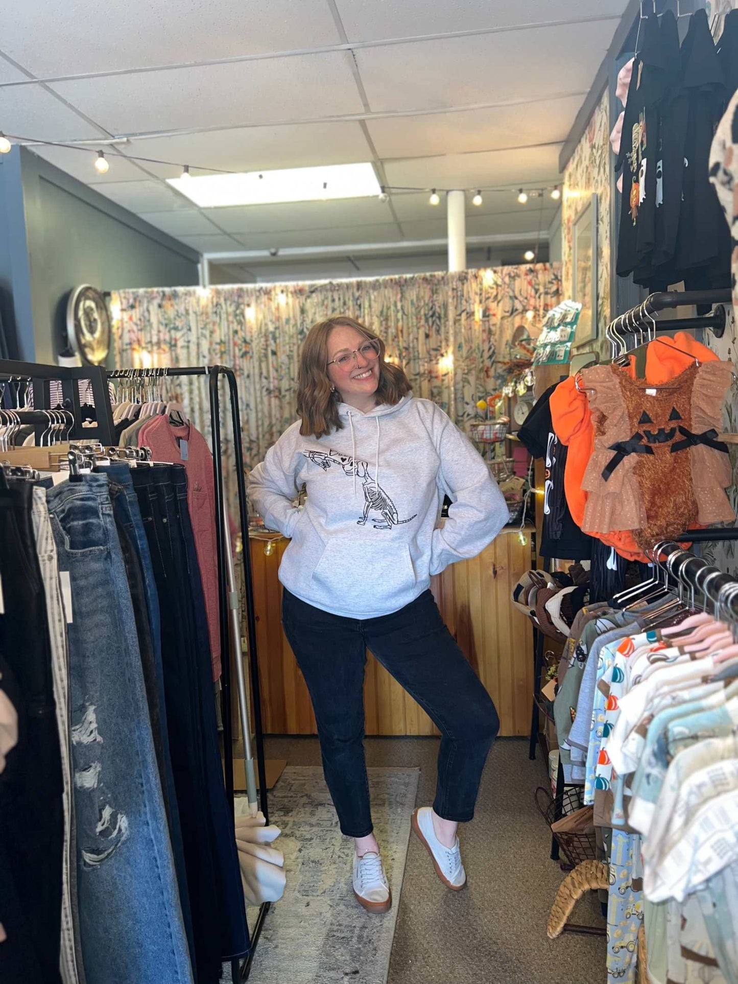 Halloween graphic skeleton dog custom sweatshirt displayed in clothing store.
