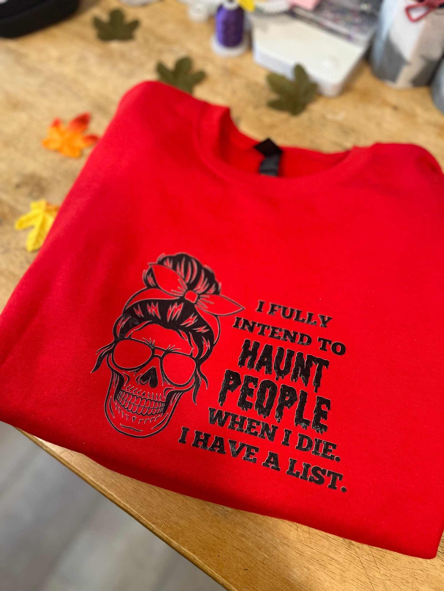 Eerie red Halloween t-shirt with "I intend to Haunt People" graphic design, perfect for a spooky look.