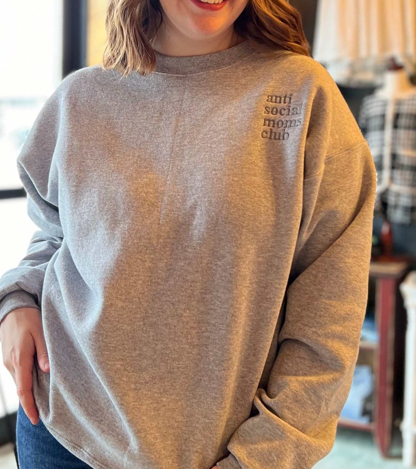 Anti Social Moms Club embroidered crewneck sweatshirt on a woman.